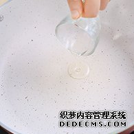 步驟圖:電陶爐開大火，煎炒鍋中倒入少許油。