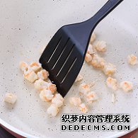 步驟圖:油熱后倒入蝦仁，用鍋鏟翻炒2分鐘至變色，盛出碗中備